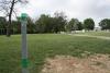 Hole 1. 256 ft.There is a tree mid way on the right hand side. Behind the basket are some trees.