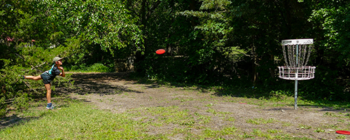 A child throwing a putt in the circle while keeping her front foot firmly on the ground